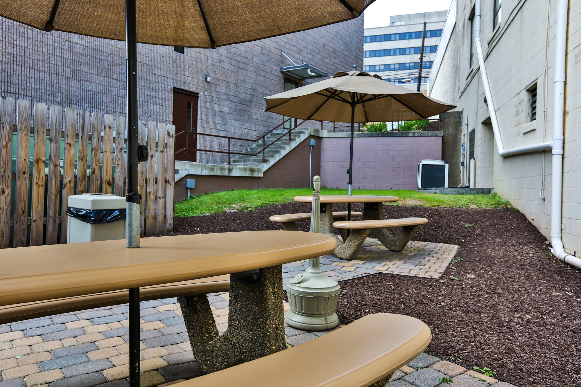 Outdoor private patio area with umbrellas and tables to sit at