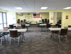The common/dining room with many tables and seating